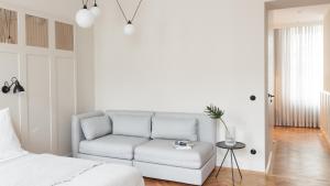 a white couch in a bedroom with a bed at Hotel Zipser in Vienna