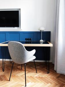 a desk with a chair and a television in a room at Hotel Zipser in Vienna