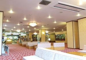 een bibliotheek met stoelen en tafels in een gebouw bij Higashiyama Park Hotel Shinfugetsu in Aizuwakamatsu