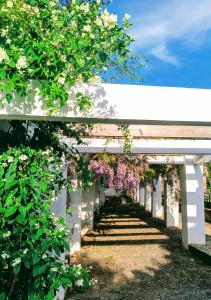 um banco branco com flores penduradas em Casa Rural Castillo de Cáceres em Cáceres