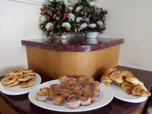 tres platos de bollería y magdalenas en una mesa en Hotel Airlink Castle, en Nedumbassery