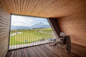 d'un balcon avec une grande fenêtre, une table et des chaises. dans l'établissement Gasthaus Badhof - Golfhotel, à Lucerne