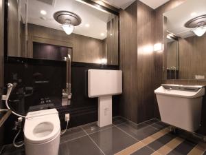 a bathroom with a toilet and a sink at APA Hotel Shin Osaka Ekiminami in Osaka