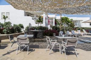 een patio met tafels en stoelen onder een tent bij Portes Houses in Koufonisia