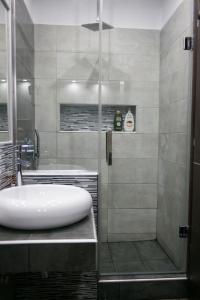 bagno con doccia e lavandino bianco di Zen Luxury Living a Salonicco