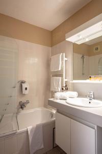 a bathroom with a sink and a bath tub and a sink at Park Hotel Airport in Charleroi