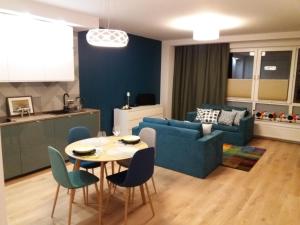 a living room with a blue couch and a table and chairs at Apartament Pruszków in Pruszków