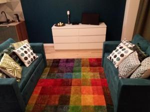 a living room with two couches and a colorful rug at Apartament Pruszków in Pruszków