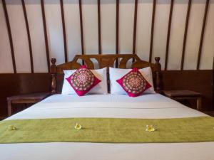 Una cama con dos almohadas encima. en Gili Turtle Beach Resort, en Gili Trawangan