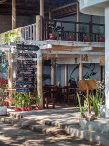 un restaurante con un cartel, mesas y sillas en Gili Turtle Beach Resort, en Gili Trawangan