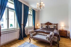 um quarto com uma cama, uma cadeira e janelas em Karlsbad Prestige em Karlovy Vary