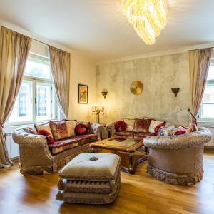 uma sala de estar com sofás e um lustre em Karlsbad Prestige em Karlovy Vary