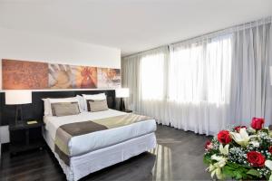 een slaapkamer met een bed en bloemen in een kamer bij Hotel Eurotel Providencia in Santiago