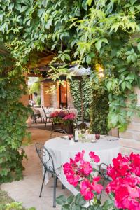 a white table with pink flowers on a patio at Tenuta Di Canonica in Todi