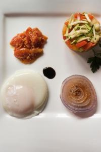 a white plate topped with three different types of food at Tenuta Di Canonica in Todi