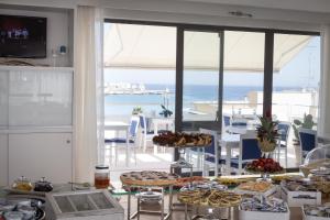 einen Tisch mit Essen und Meerblick in der Unterkunft Hotel Albània in Otranto