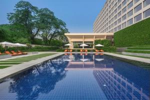 una piscina di fronte a un edificio di The Oberoi New Delhi a Nuova Delhi