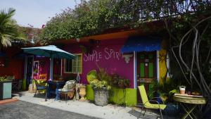 a colorful house with a table and chairs and an umbrella at Villa Brasil Motel in Los Angeles