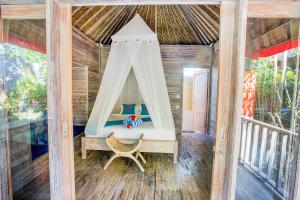 una camera da letto in una casa sull'albero con un letto e un'altalena di Lotus Garden Huts a Nusa Lembongan