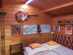 um quarto com uma cama e uma guitarra na parede em Páros faház em Balatonföldvár