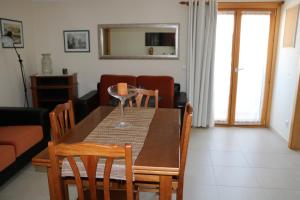 une salle à manger avec une table et un verre de vin dans l'établissement Grace Beach House, à Nazaré