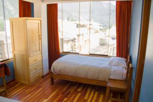 1 dormitorio con cama y ventana grande en Tumy house B&B, en Ollantaytambo