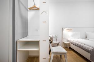 Dormitorio pequeño con cama, escritorio y silla en #draugunamai, en Druskininkai