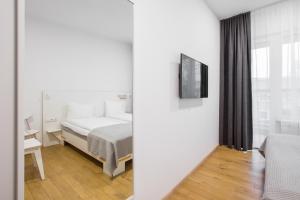 1 dormitorio con 1 cama y TV en la pared en #draugunamai, en Druskininkai