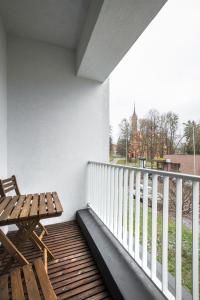 un banco de madera sentado en un balcón con vistas en #draugunamai, en Druskininkai