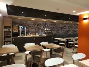 a restaurant with tables and chairs and a bar at Hôtel Montchapet Dijon Centre in Dijon