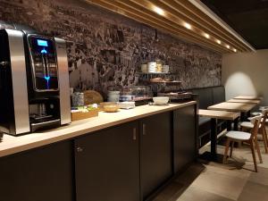 a kitchen with a counter with a coffee maker on it at Hôtel Montchapet Dijon Centre in Dijon