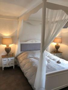 uma cama branca com dossel num quarto em Suites Residences Spa em Colmar