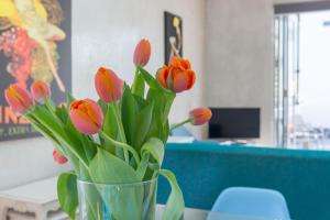 un jarrón lleno de tulipanes rojos y rosados sentados en una mesa en Chic East Sydney Pad, en Sídney