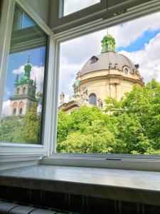 une fenêtre ouverte avec vue sur un bâtiment dans l'établissement Apartment Ryadom S Ploshadiu Rynok, à Lviv