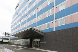 een groot gebouw met blauw en roze bij Hotel Super Tomari in Fujieda