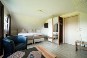 a bedroom with a bed and a chair in a room at Gästehaus Marichen in Aurich