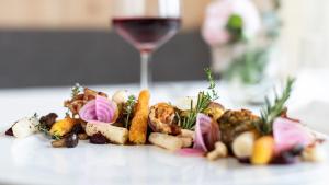 un plato de comida con una copa de vino en Ladurner, en Lagundo