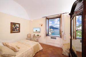 1 dormitorio con cama y ventana grande en Villa Alba d'Oro, en Amalfi