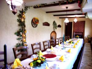 een lange tafel met stoelen en borden eten bij Gaststätte & Pension Jiedlitz in Burkau