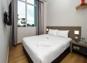 - une chambre avec un grand lit blanc et une fenêtre dans l'établissement Tune Hotel - 1Borneo Kota Kinabalu, à Kota Kinabalu