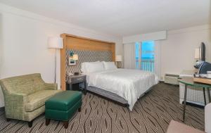 Habitación de hotel con cama y silla en Holiday Inn Resort Oceanfront at Surfside Beach, an IHG Hotel, en Myrtle Beach