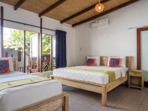 2 camas en una habitación con ventanas en Gili Turtle Beach Resort, en Gili Trawangan