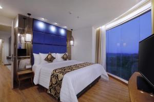 1 dormitorio con cama grande y ventana grande en The Alana Hotel and Conference Sentul City by ASTON, en Bogor