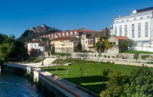 eine Gruppe von Gebäuden neben einem Fluss in der Unterkunft Hotel D. Dinis in Leiria