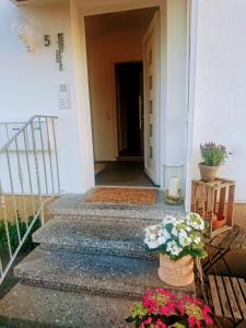 a hallway with a door and flowers on the stairs at Weinblick in Besigheim