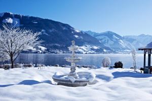 uma fonte na neve em frente a um lago em Grand Hotel Zell am See em Zell am See