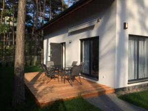 a deck with a table and chairs on a house at The Place by Baltic sea in Łukęcin