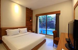 Mutiara Bali Boutique Resort & Villa tesisinde bir odada yatak veya yataklar