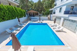 - une piscine avec des chaises et une maison dans l'établissement Forest Park Hotel, à Kemer