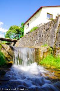 uma pequena cascata ao lado de um rio em Domek nad potokiem em Kluszkowce